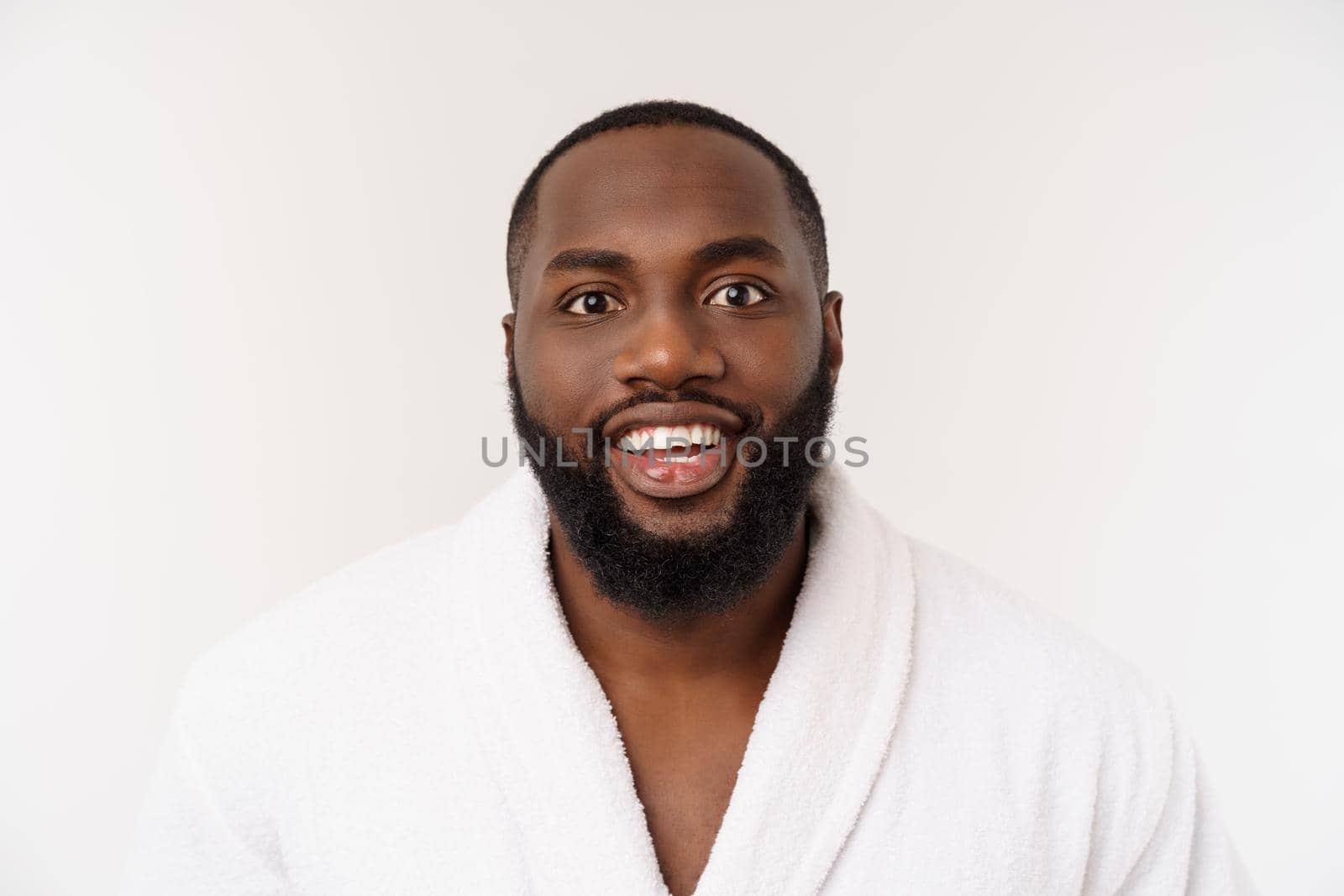 Black guy wearing a bathrobe pointing finger with surprise and happy emotion. Isolated over whtie background