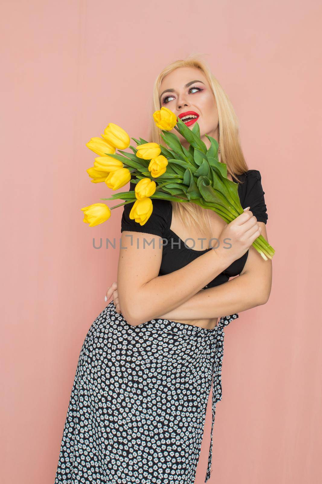 Woman in black top and skirt holding yellow tulips by Bonda