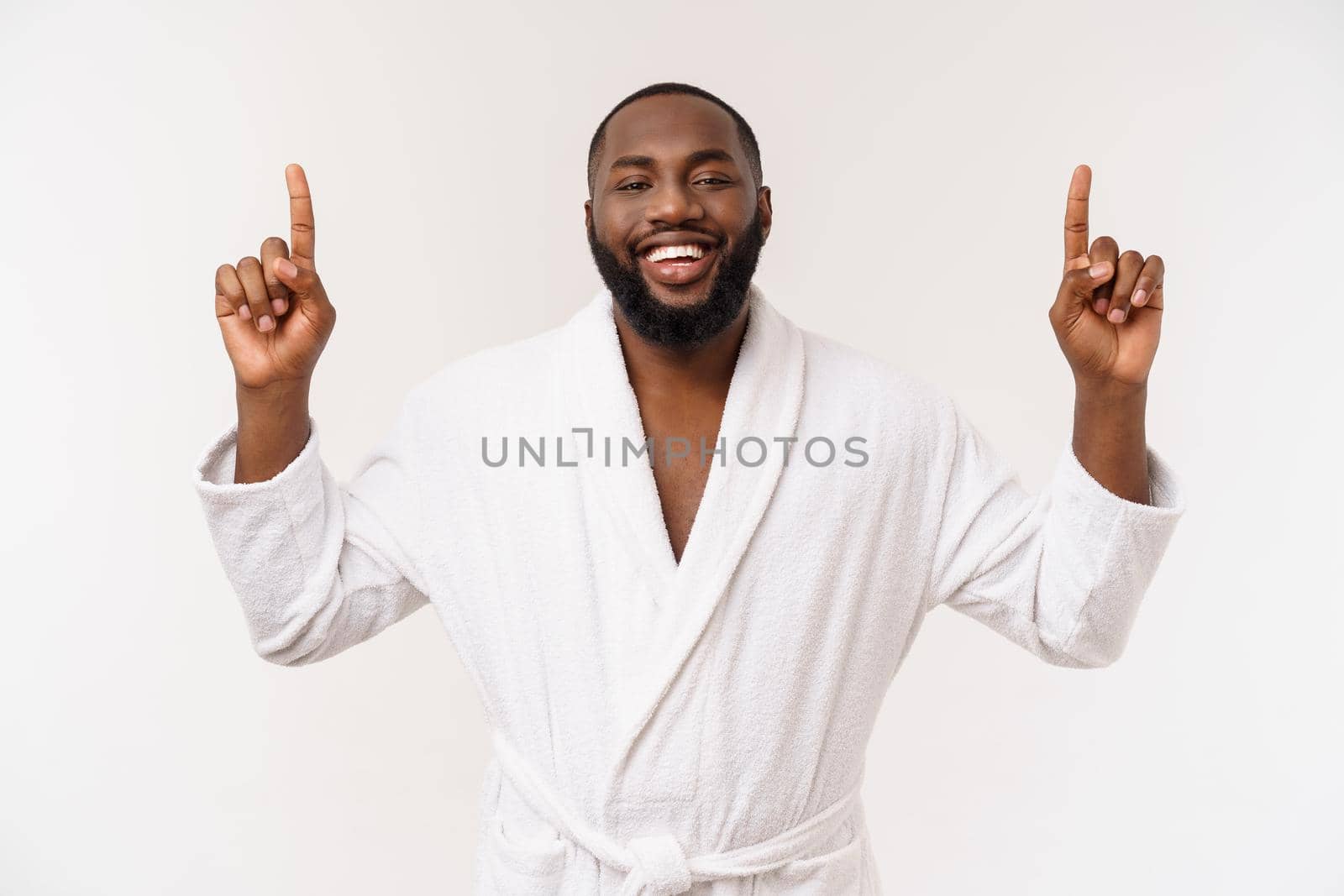 Black guy wearing a bathrobe pointing finger with surprise and happy emotion. Isolated over whtie background. by Benzoix