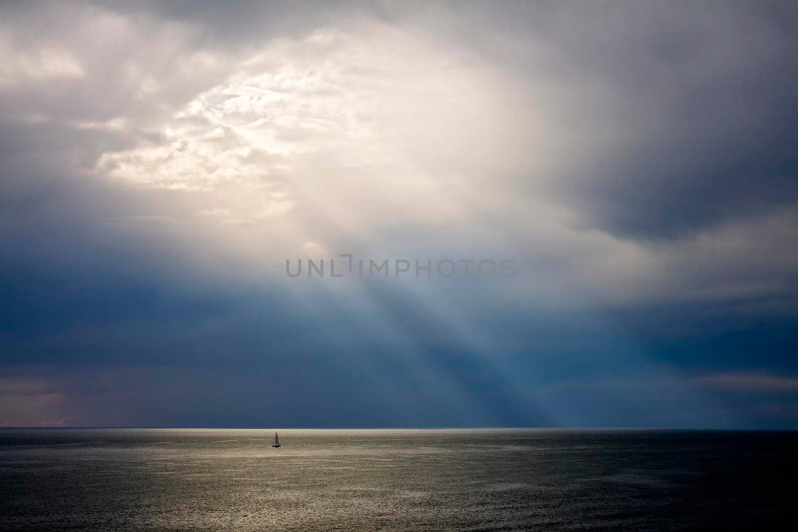 Sunbeams sunset on mediterranean sea with sail boat by Jacopo