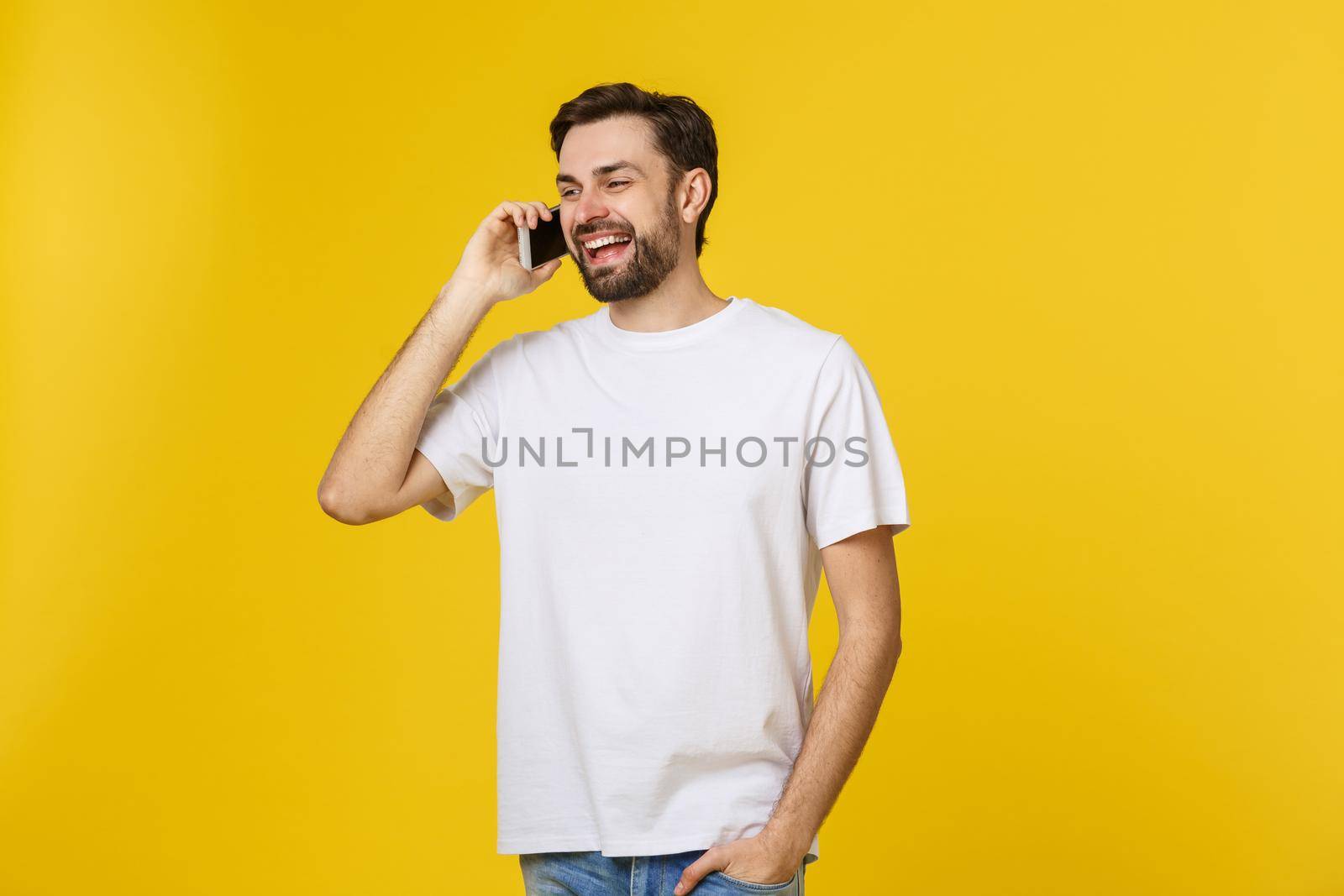 young casual man talking on the phone isolated on yellow background by Benzoix