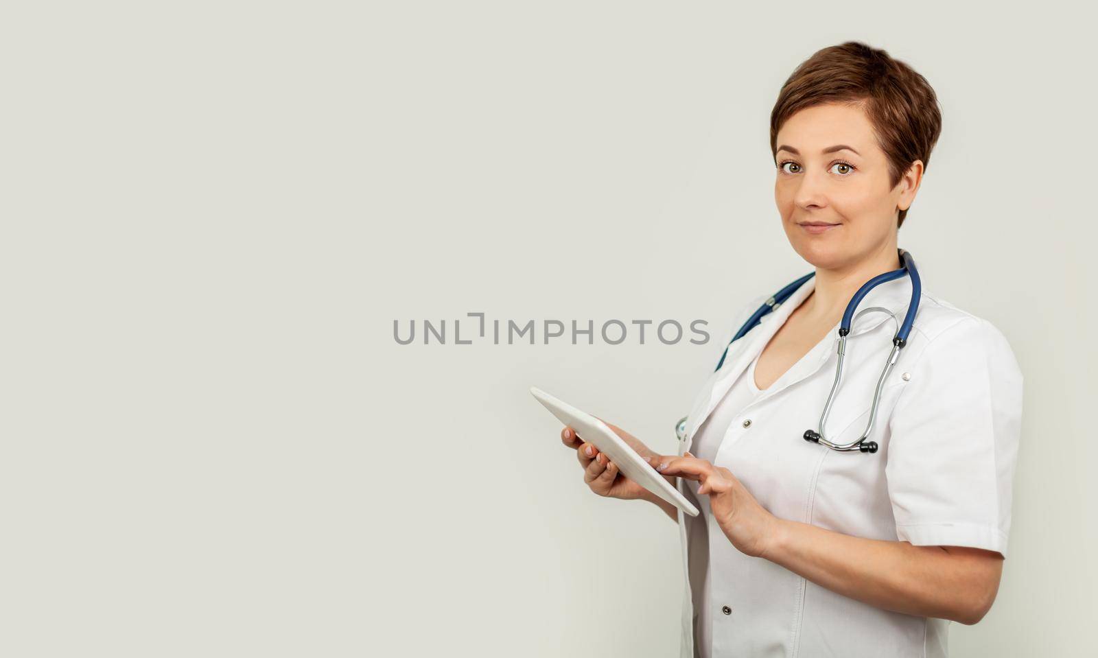 Portrait of a female doctor using her digital tablet. Female doctor using tablet and checking with analysis on a virtual interface. Medicine. Medical science and biotechnology.