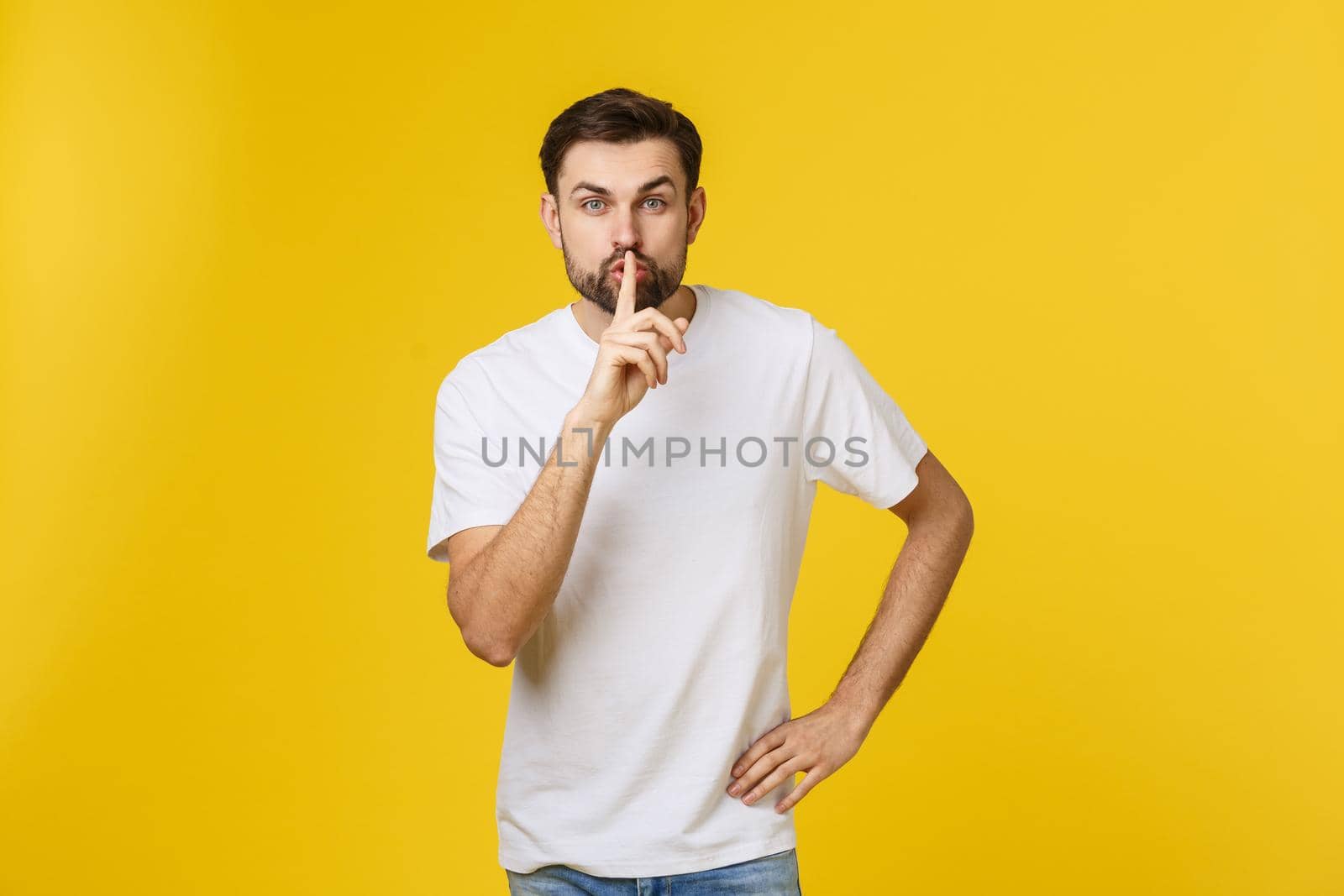 young man making silence gesture, shhhhh. Isolated over yellow background. by Benzoix