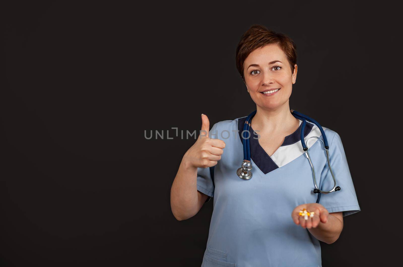 Young American doctor woman shows a background success sign making a positive gesture with hand, thumbs up smiling and happy. Looking at the camera with a cheerful expression, winner gesture.