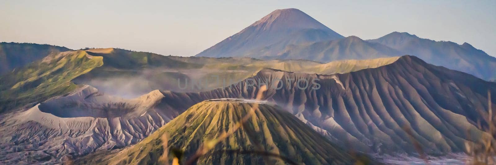 BANNER, LONG FORMAT Sunrise at the Bromo Tengger Semeru National Park on the Java Island, Indonesia. View on the Bromo or Gunung Bromo on Indonesian, Semeru and other volcanoes located inside of the Sea of Sand within the Tengger Caldera. One of the most famous volcanic objects in the world. Travel to Indonesia concept by galitskaya