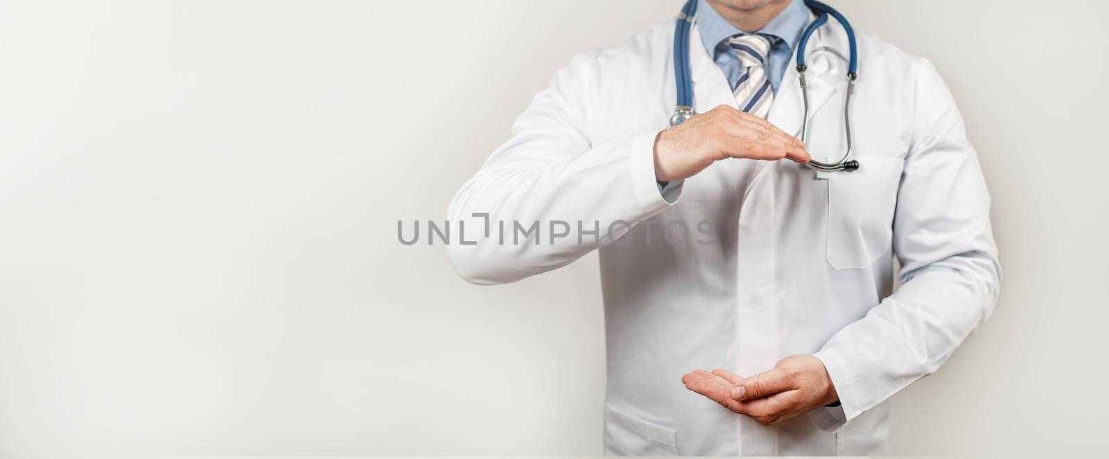 Doctor with two hands gesture health and life insurance for the whole family concept. Practitioner with a protective gesture.