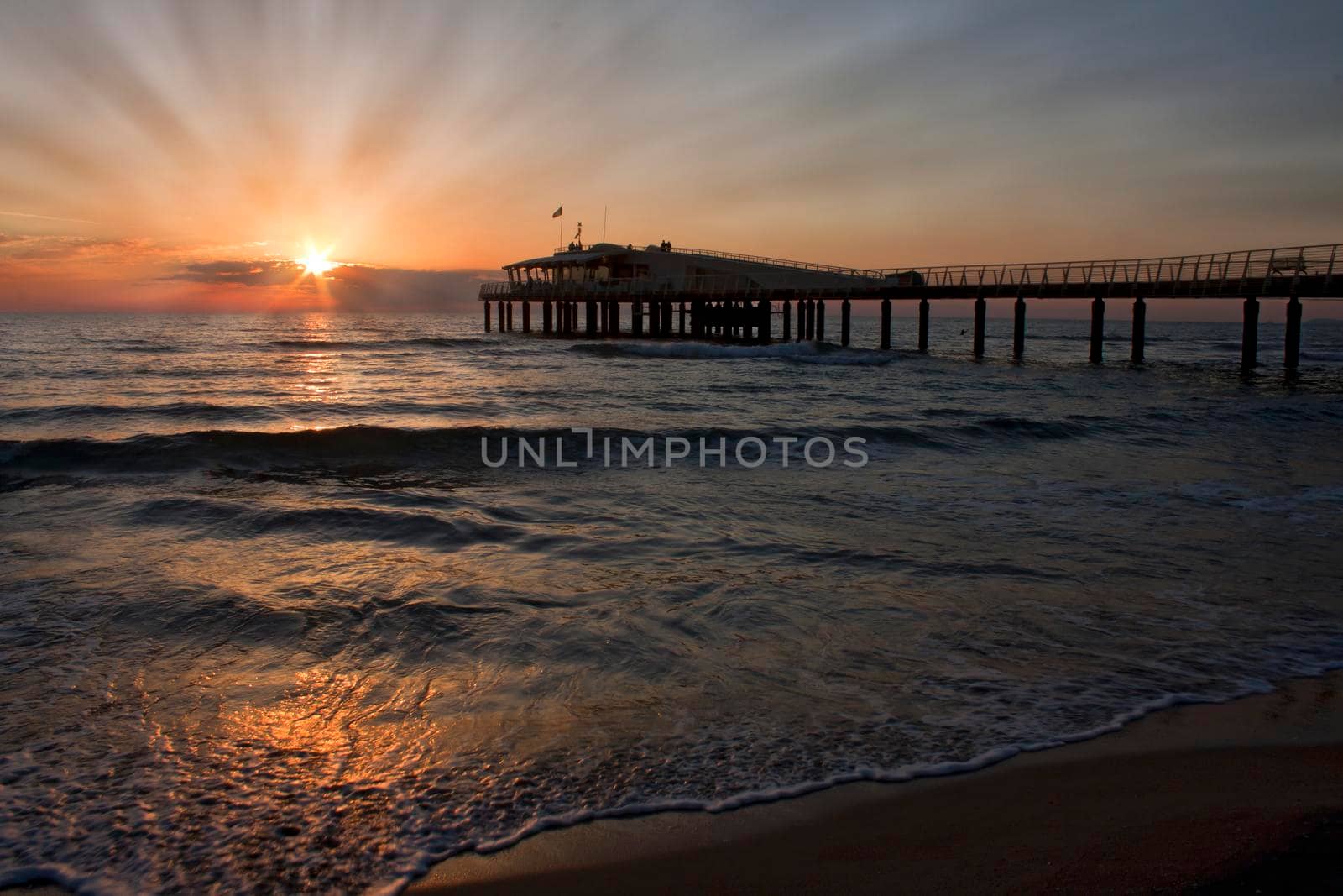 Lido di Camaiore peer and beach, Tuscany, Italy at sunset