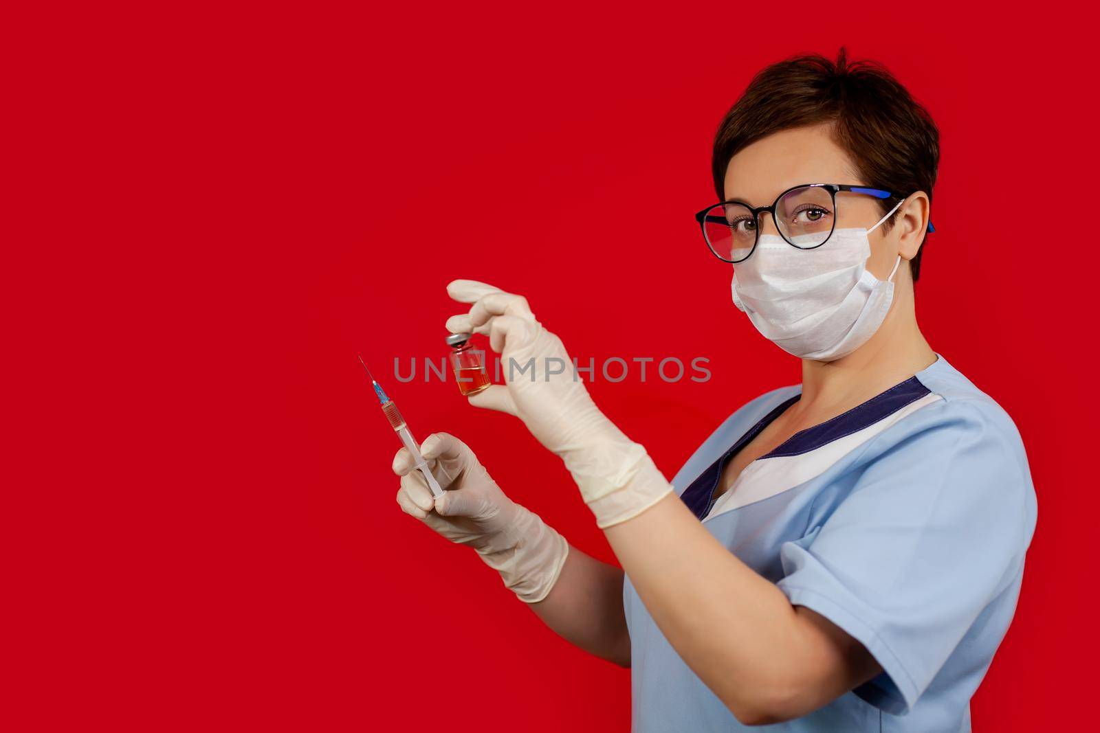 A doctor or nurse in nitrile gloves holds in his hand a vaccine vaccinated against influenza, measles, coronavirus COVID-19 for vaccination of children and adults, the concept of medicine and drugs.