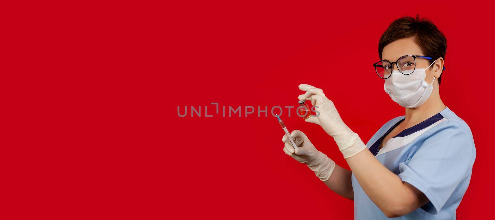 A doctor or nurse in nitrile gloves holds in his hand a vaccine vaccinated against influenza, measles, coronavirus COVID-19 for vaccination of children and adults, the concept of medicine and drugs.