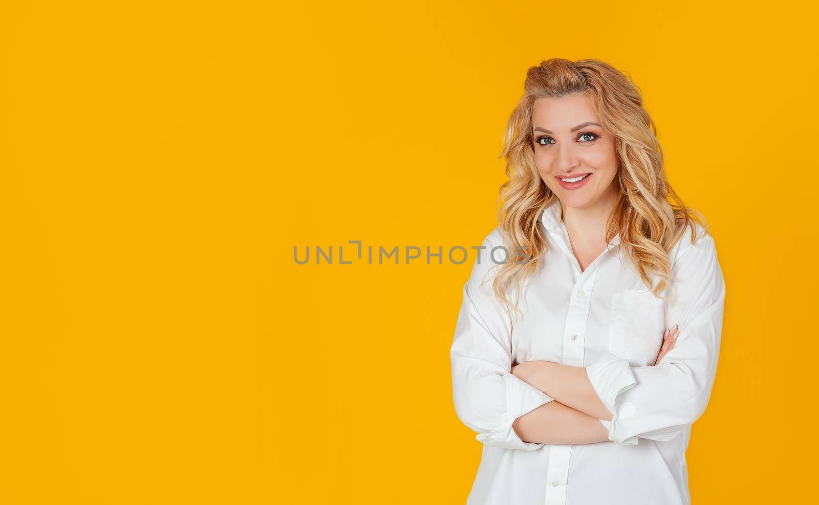 Attractive self-confident beautiful woman crossing her arms chest self-confident pose smiling energetic ready to achieve goals feeling lucky standing yellow background. Ready to start working today.