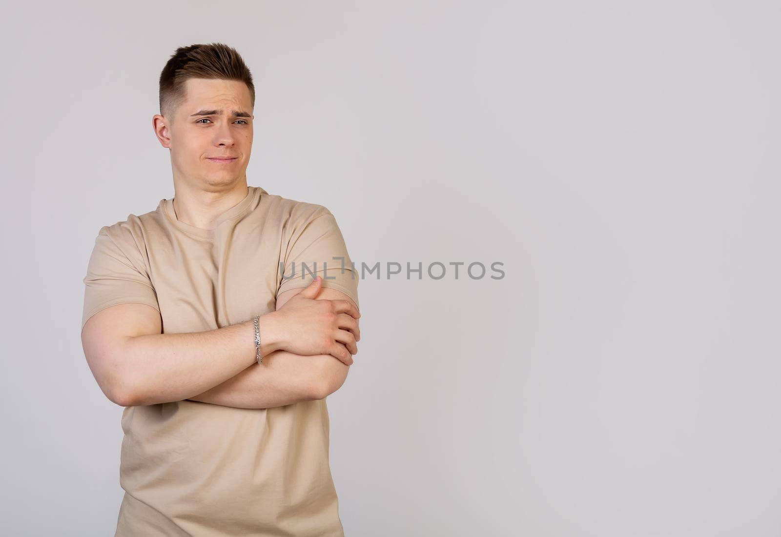 Handsome young man crossed his arms over his chest with an average expression on his face. Confident sports guy, showing off his achievements, looking at the camera. I feel great