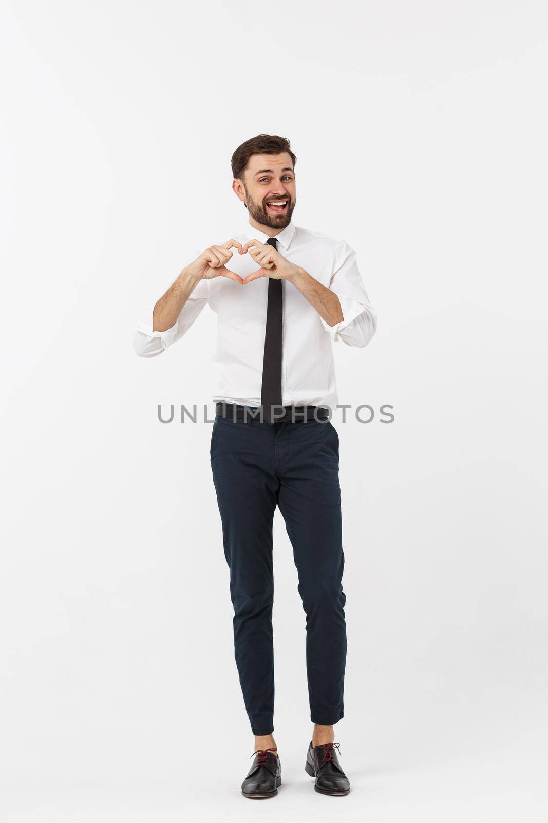 Business Concept: Portrait of charming attractive businessman holding hands in heart gesture and lifting eyebrows while smiling