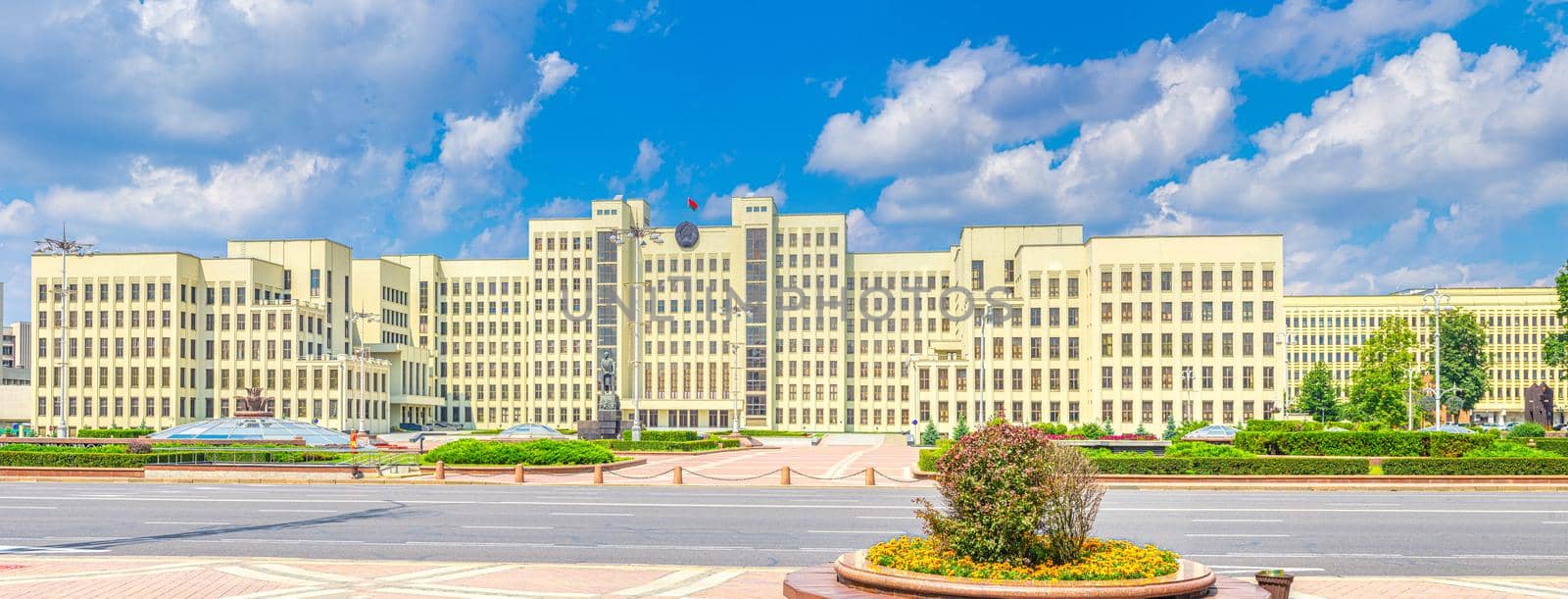 The Government House constructivism style building and Independence avenue on Independence Square in Minsk city historical centre, blue sky white clouds in sunny summer day, Republic of Belarus