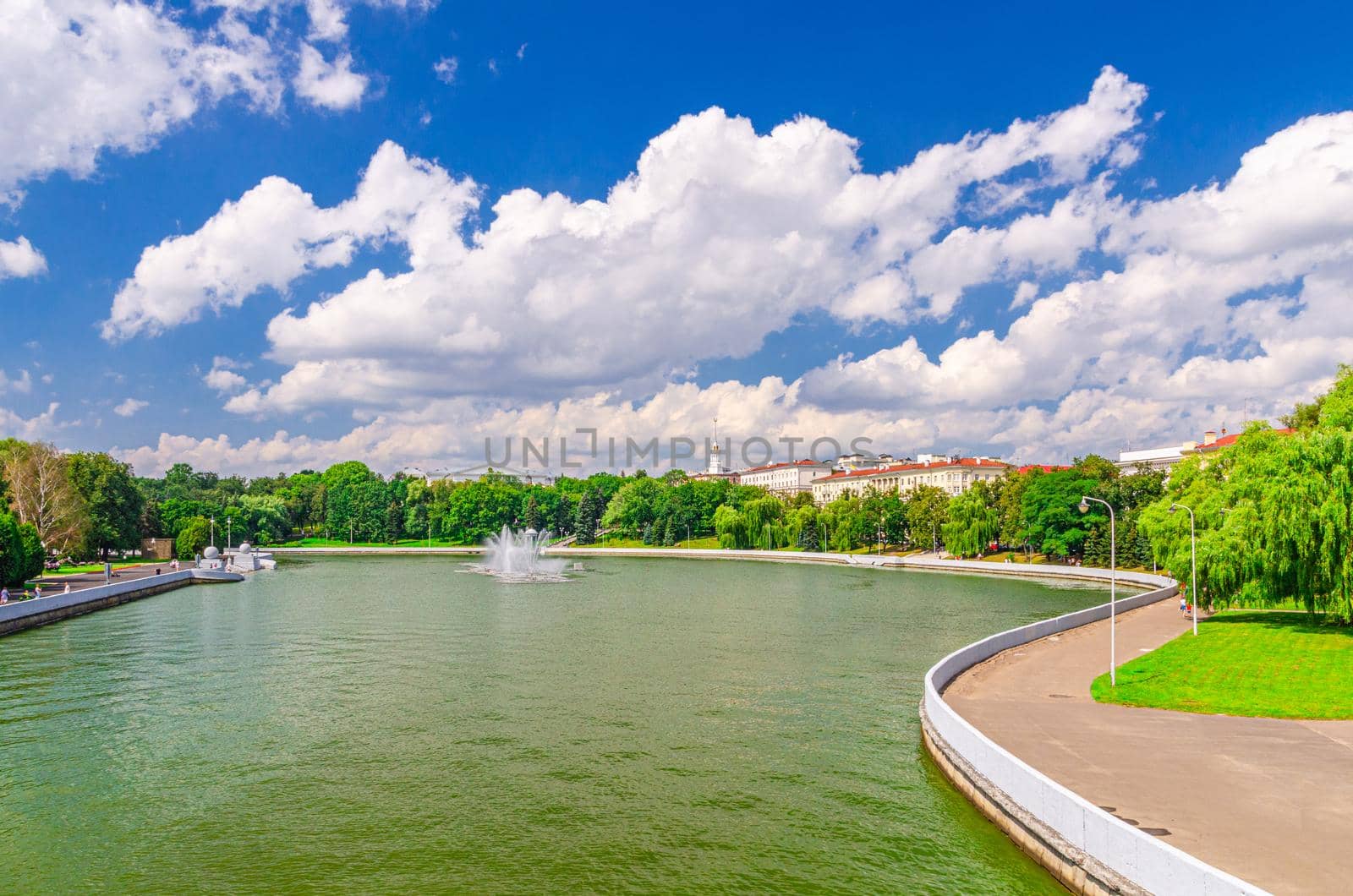 Minsk cityscape with Svislach or Svislac river embankment, Marat Kazey Park and General Headquarters building in historical centre, blue sky white clouds in sunny summer day, Republic of Belarus