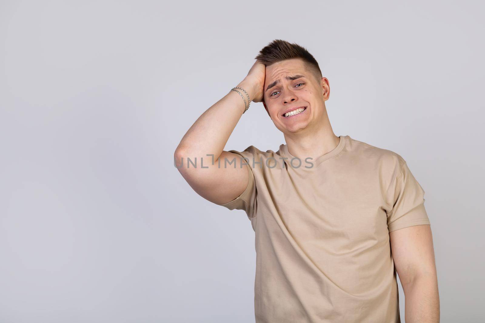 Handsome young man a man with a frightened expression on his face held his hand on the forehead of his head. Guy with a guilty expression after he remembered that he forgot to call