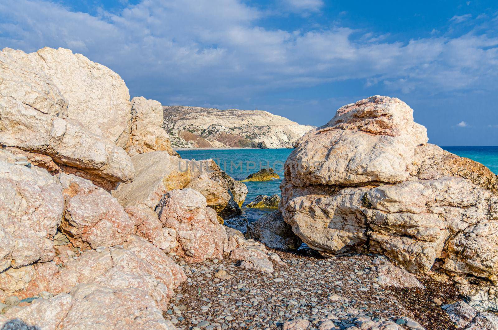 Aphrodite Beach with Stone Rocks in Aphrodite bay of Mediterranean sea water, blue sky in sunny day background, Petra tu Romiou, Cyprus