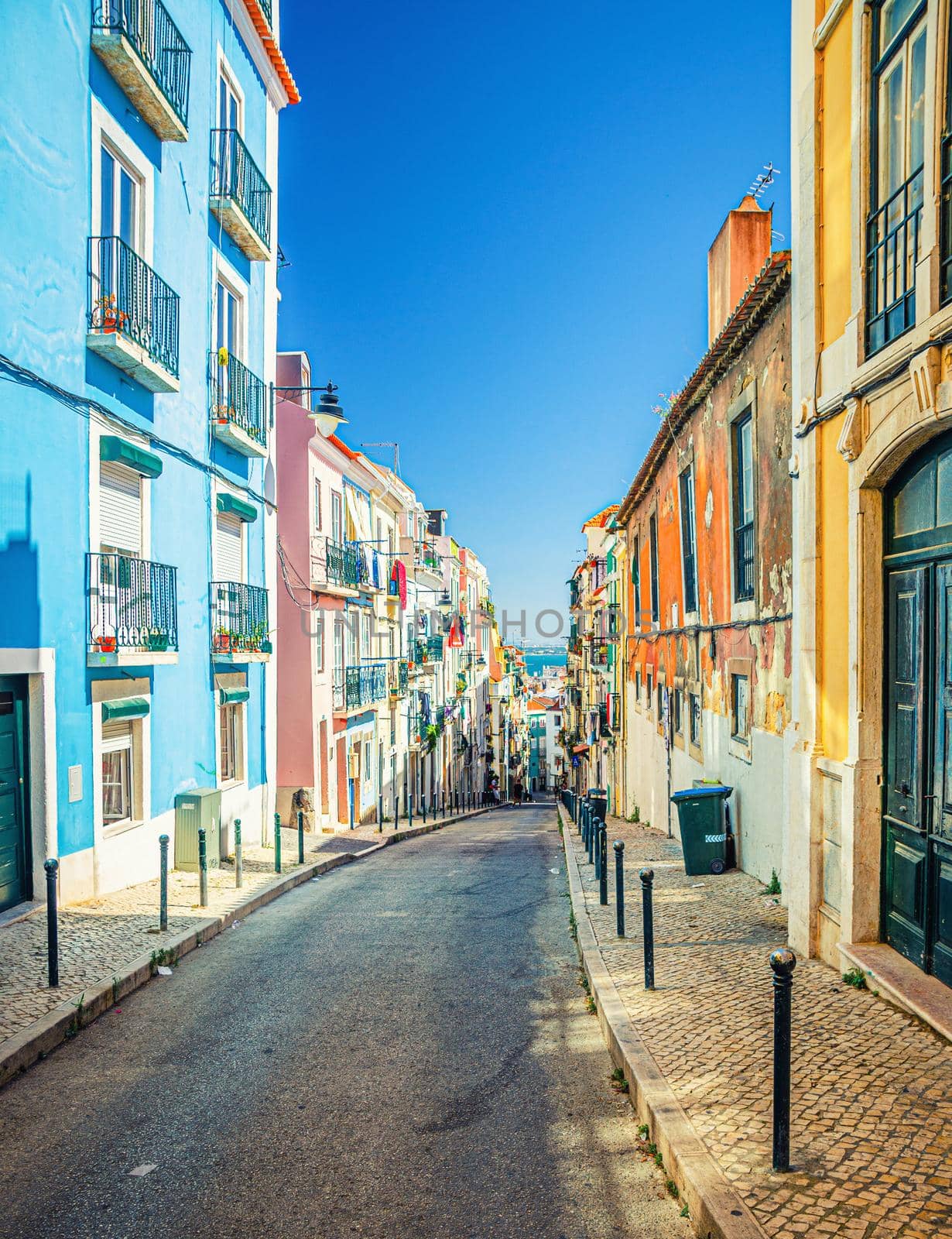 Typical narrow street with colorful multicolored traditional buildings and houses in Lisbon Lisboa historical city centre, Portugal