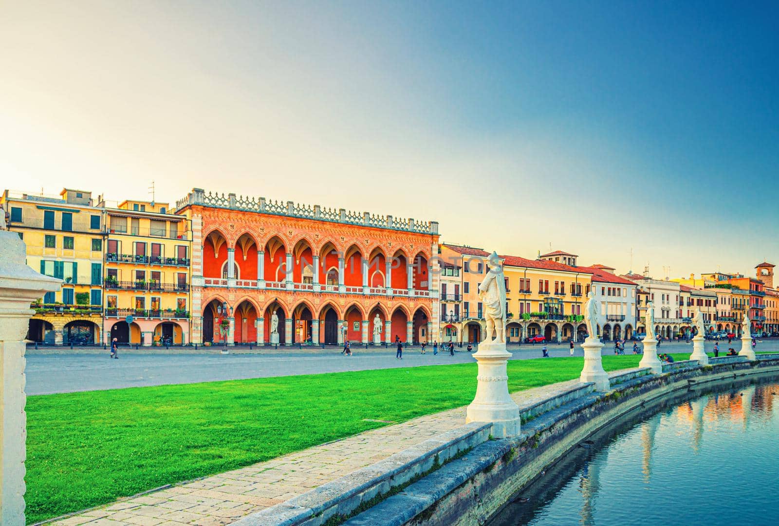 Padua cityscape with Palazzo Loggia Amulea palace neogothic style building and statues near small canal on Piazza Prato della Valle square in historical city centre, Padova town, Veneto Region, Italy