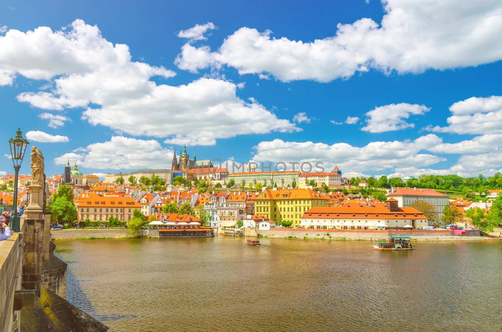 View of Prague old town, historical center with Prague Castle, St. Vitus Cathedral in Hradcany district, Charles Bridge Karluv Most over Vltava river, blue sky white clouds, Bohemia, Czech Republic
