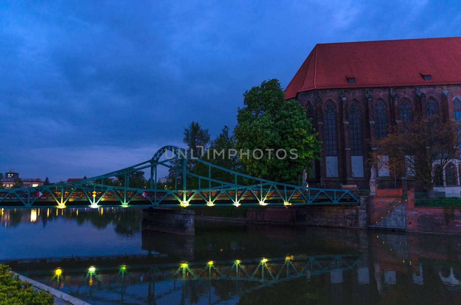 Roman Catholic parish Saint Mary church NMP on Sand island Wyspa Piasek, Tumski bridge over Odra Oder river in old town historical city centre of Wroclaw, evening view, Poland