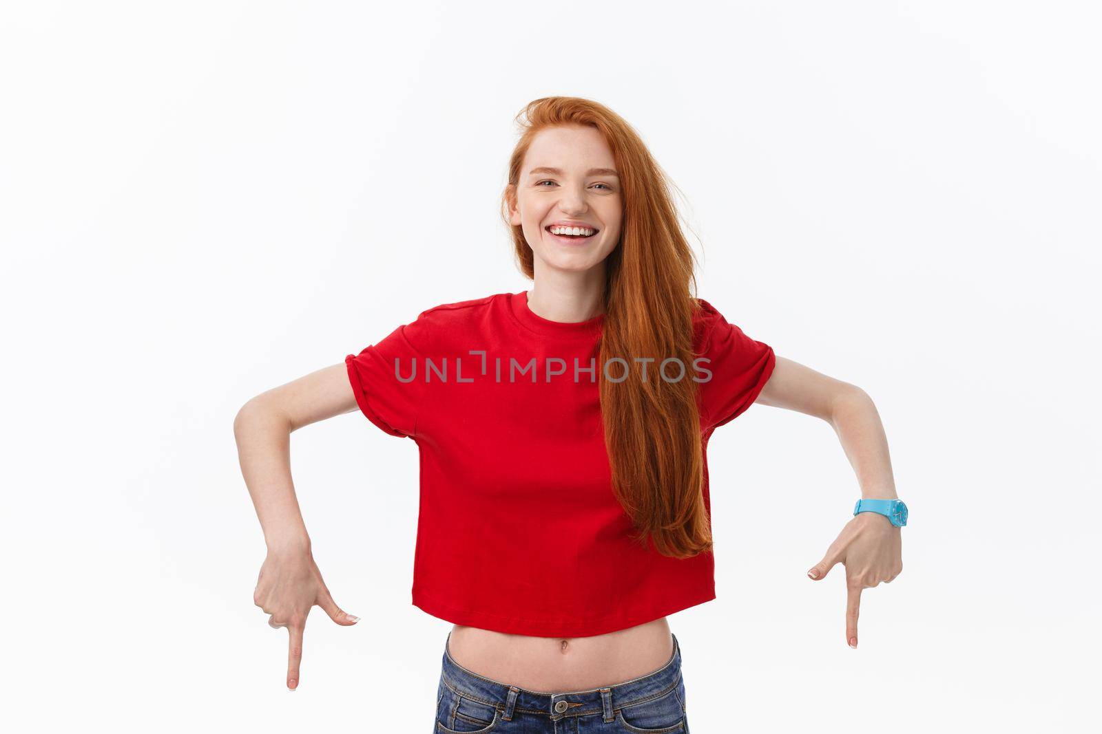 Photo of happy young woman standing isolated over white wall background. Looking camera showing copyspace pointing.