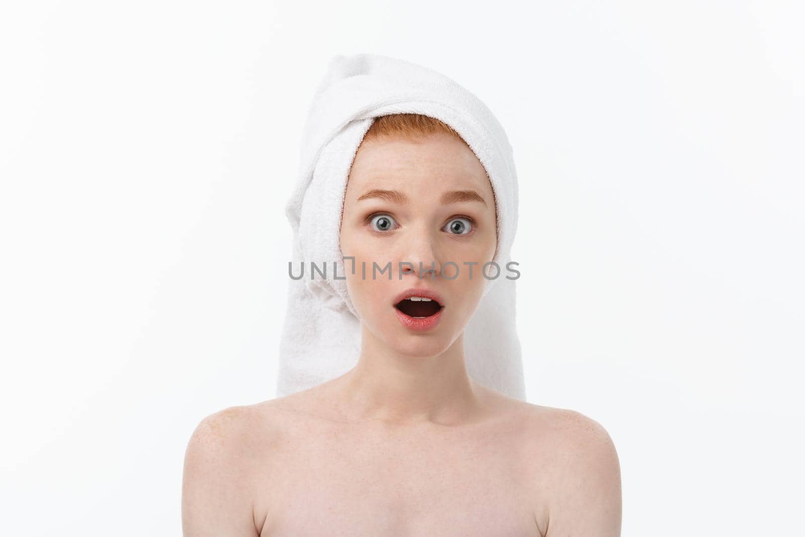 Surprised Beautiful Young Woman After Bath with A Towel On Her Head Isolated On white Background. Skin Care And Spa Theme