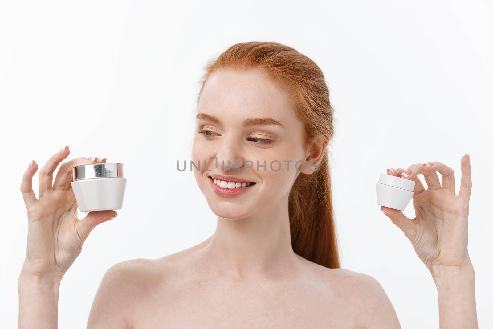 portrait of beautiful woman smiling while taking some facial cream isolated on white background with copy space