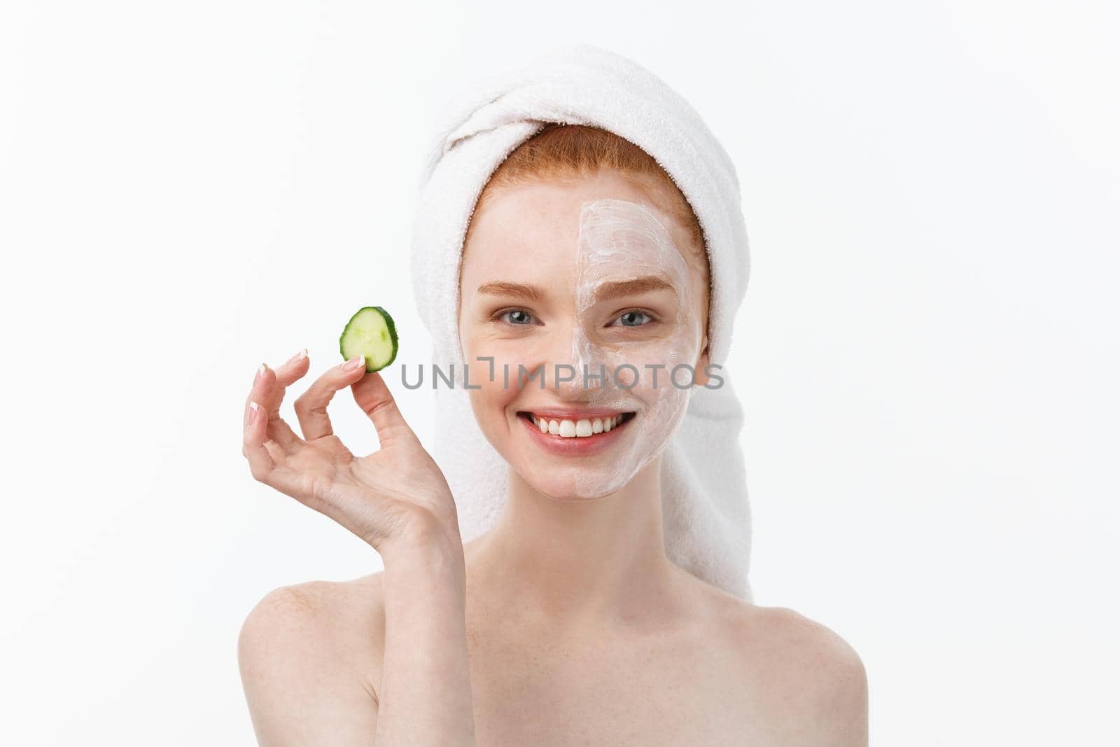 Attractive Young Woman with beautiful clean skin. White mask and cucumbers. Beauty treatments and cosmetology spa therapy. White background by Benzoix