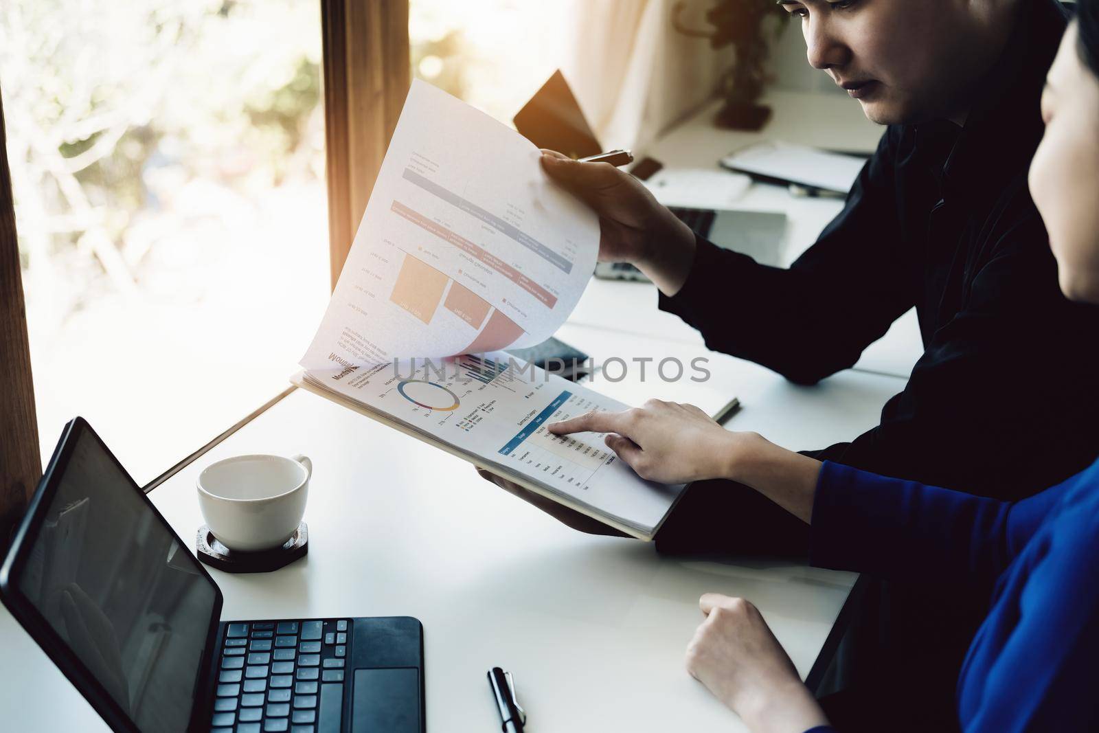 Teamwork concept, consultation, female economist holding pen pointing to budget, finance and investment documents, discussing and planning finances with male advisors in conference room.