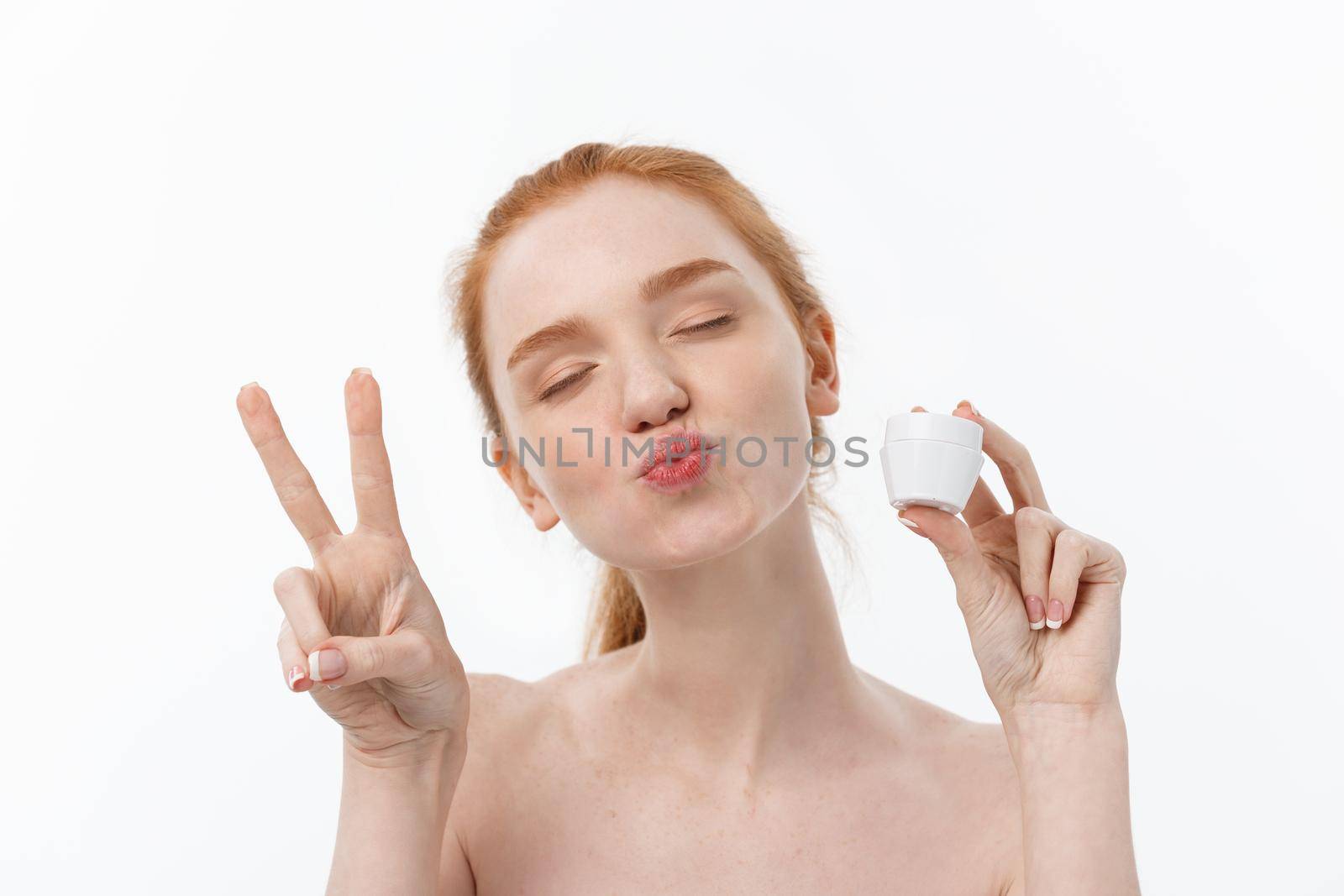 portrait of beautiful woman smiling while taking some facial cream isolated on white background with copy space