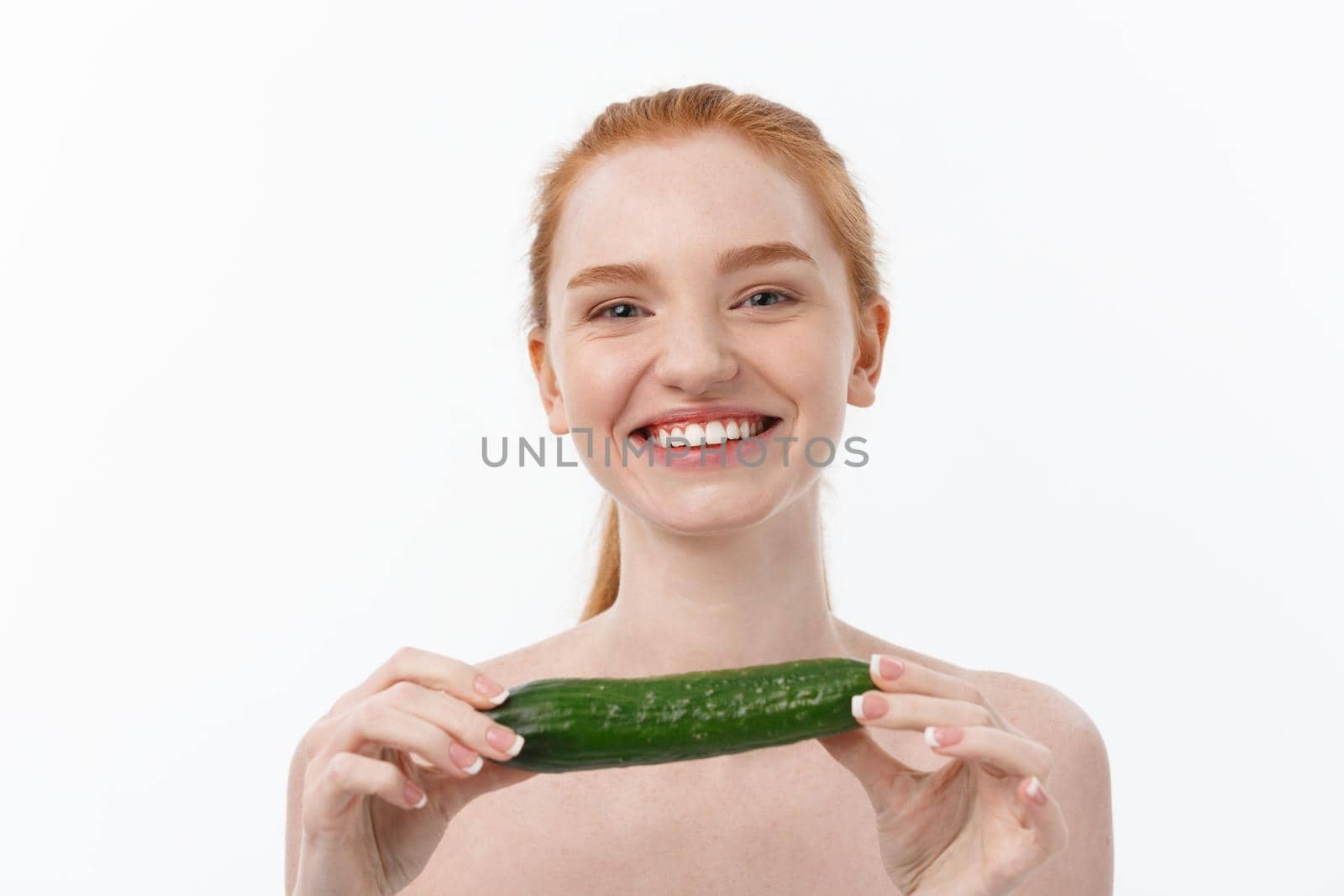 Cheerful happy beautiful girl with cucumber on her hand - isolated on white.