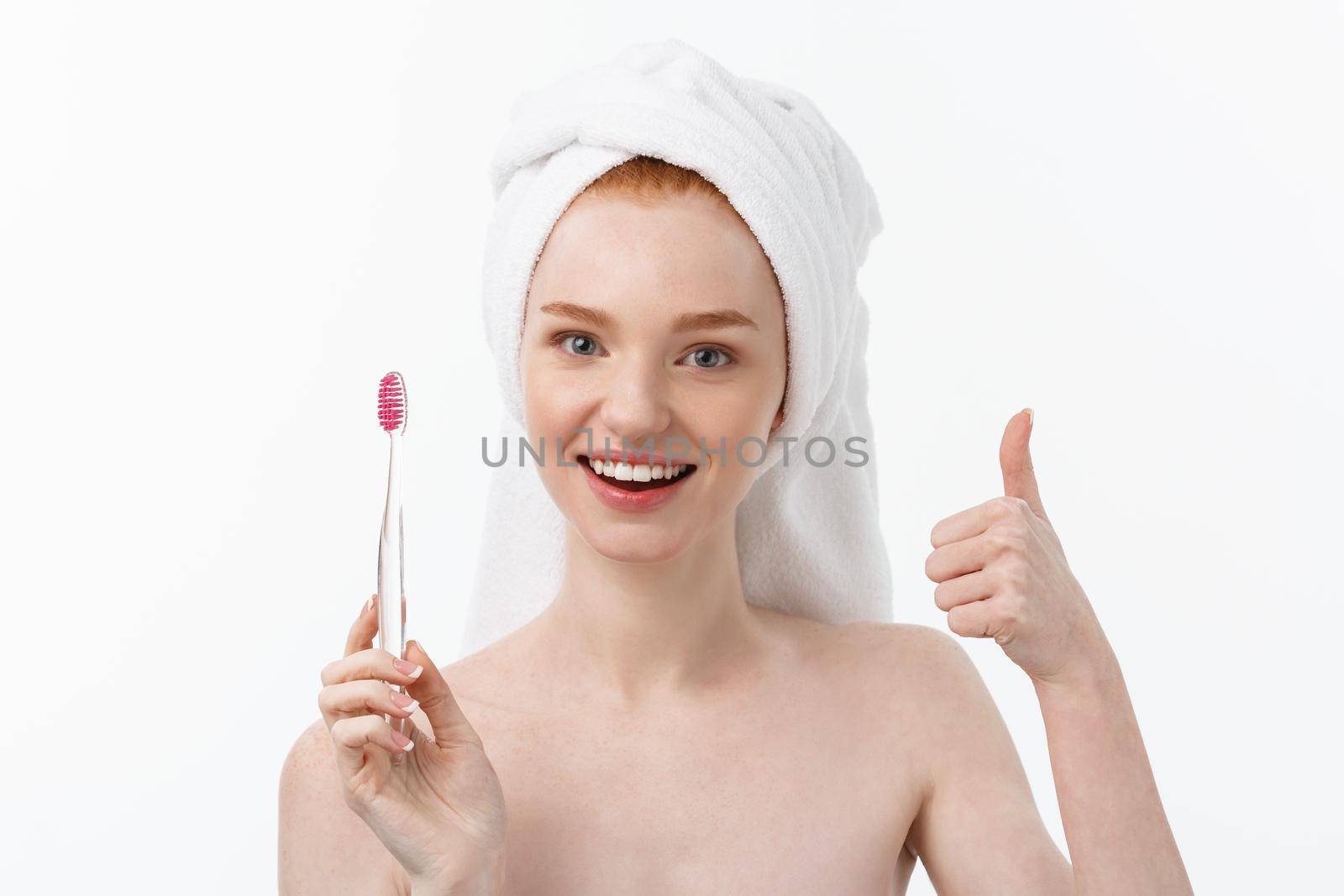 Portrait of young woman with toothbrush on grey background. by Benzoix