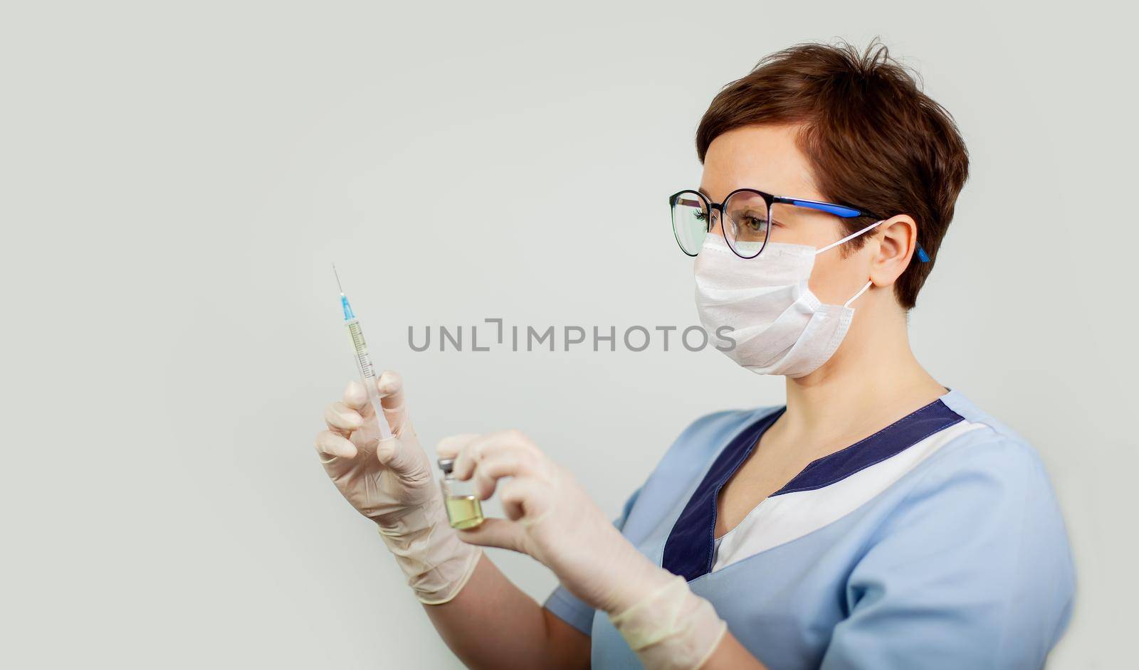 A doctor or nurse in nitrile gloves holds in his hand a vaccine vaccinated against influenza, measles, coronavirus COVID-19 for vaccination of children and adults, the concept of medicine and drugs.
