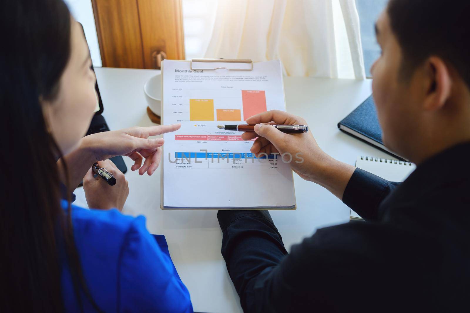 Teamwork concept, consultation, male economist holding pen pointing to budget, finance and investment documents, discussing and planning finances with female advisors in conference room