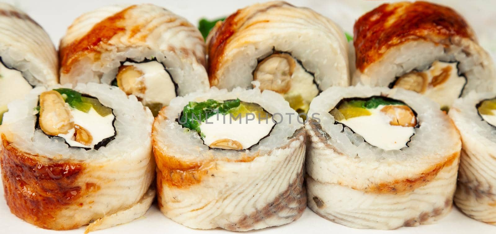 Sushi roll with eel and chuka salad on a white plate, classic Japanese sushi. Traditional Japanese food with maki. Delicious pieces of sushi. For the restaurant menu. copyspace.