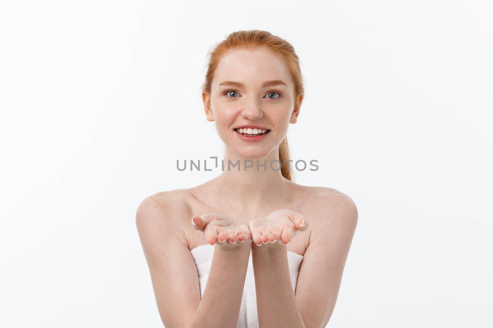 Skin care beauty woman showing empty palm with copy space for product. Excited smiling Caucasian female beauty model isolated on white background