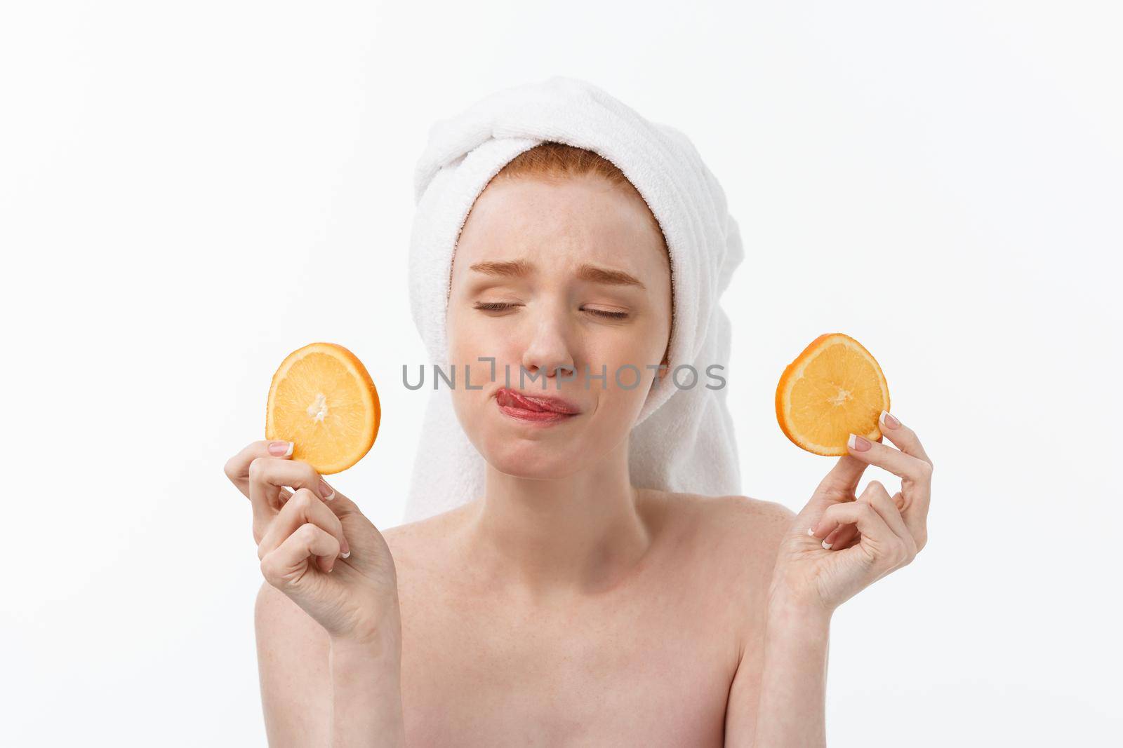 Great food for a healthy lifestyle. Beautiful young shirtless woman holding piece of orange standing against white background