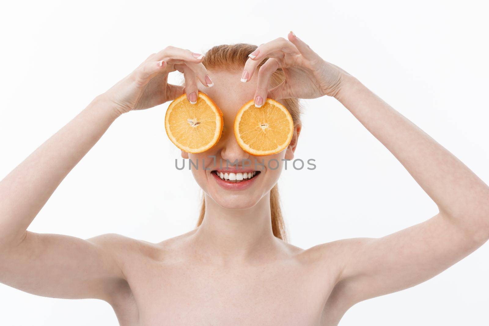 Great food for a healthy lifestyle. Beautiful young shirtless woman holding piece of orange standing against white background