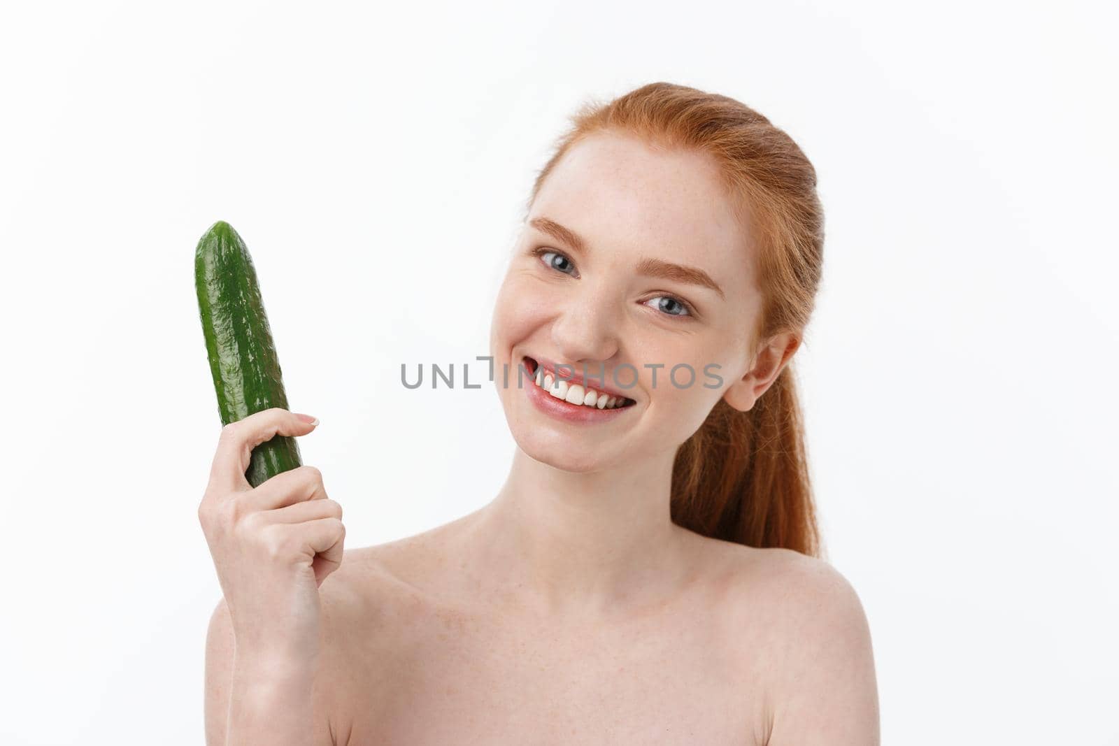 Cheerful happy beautiful girl with cucumber on her hand - isolated on white.