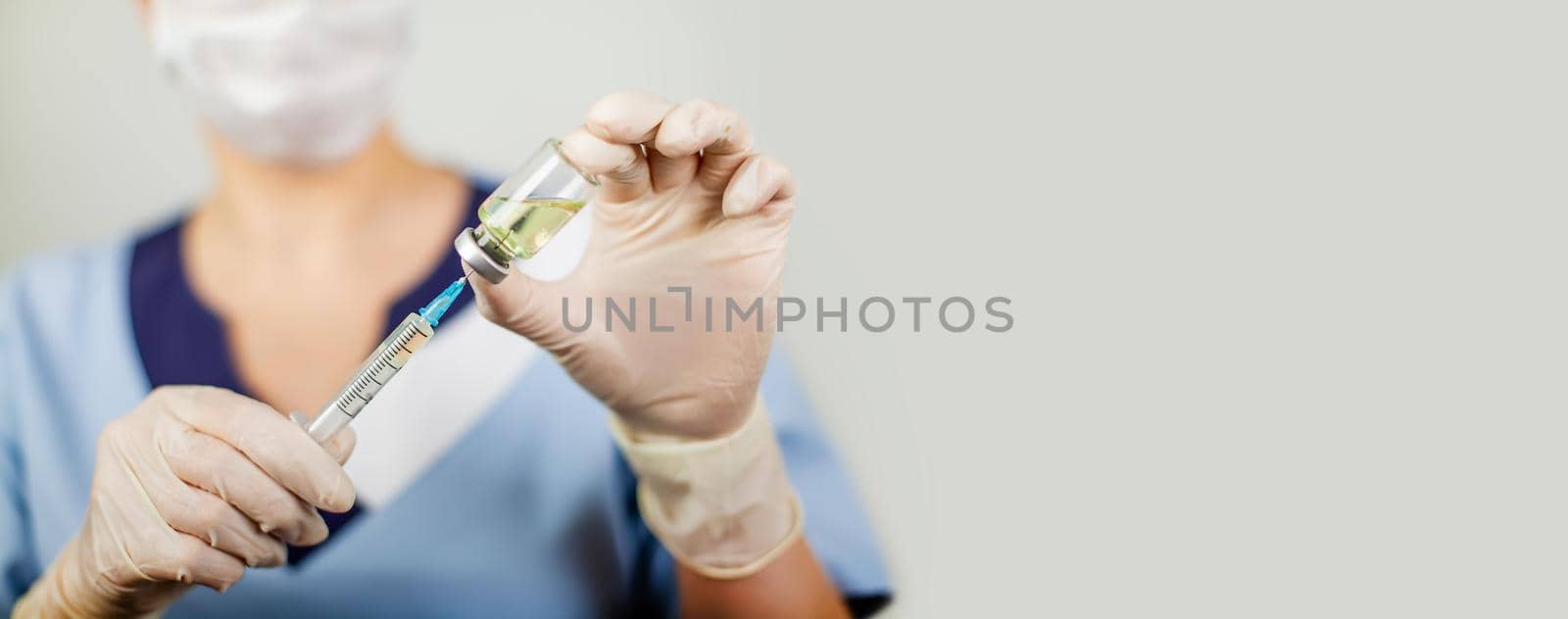 Hand of a doctor or nurse in nitrile gloves with a syringe needle vaccinated against influenza, measles, coronavirus COVID-19 for vaccinating children and adults, the concept of medicine and medicines