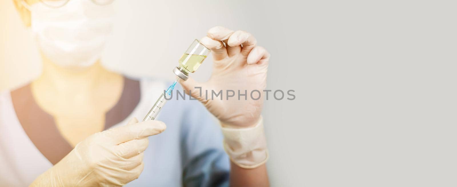 Hand of a doctor or nurse in nitrile gloves with a syringe needle vaccinated against influenza, measles, coronavirus COVID-19 for vaccinating children and adults, the concept of medicine and medicines