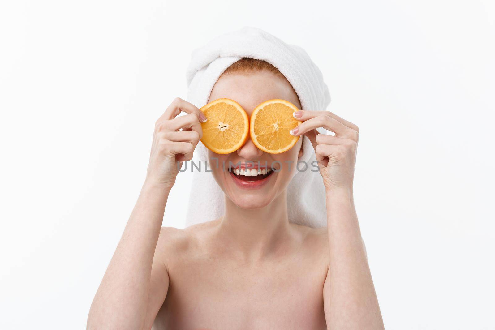 Great food for a healthy lifestyle. Beautiful young shirtless woman holding piece of orange standing against white background