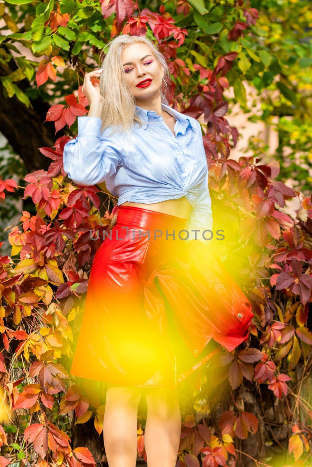 Stylish blonde woman on autumn street by Bonda