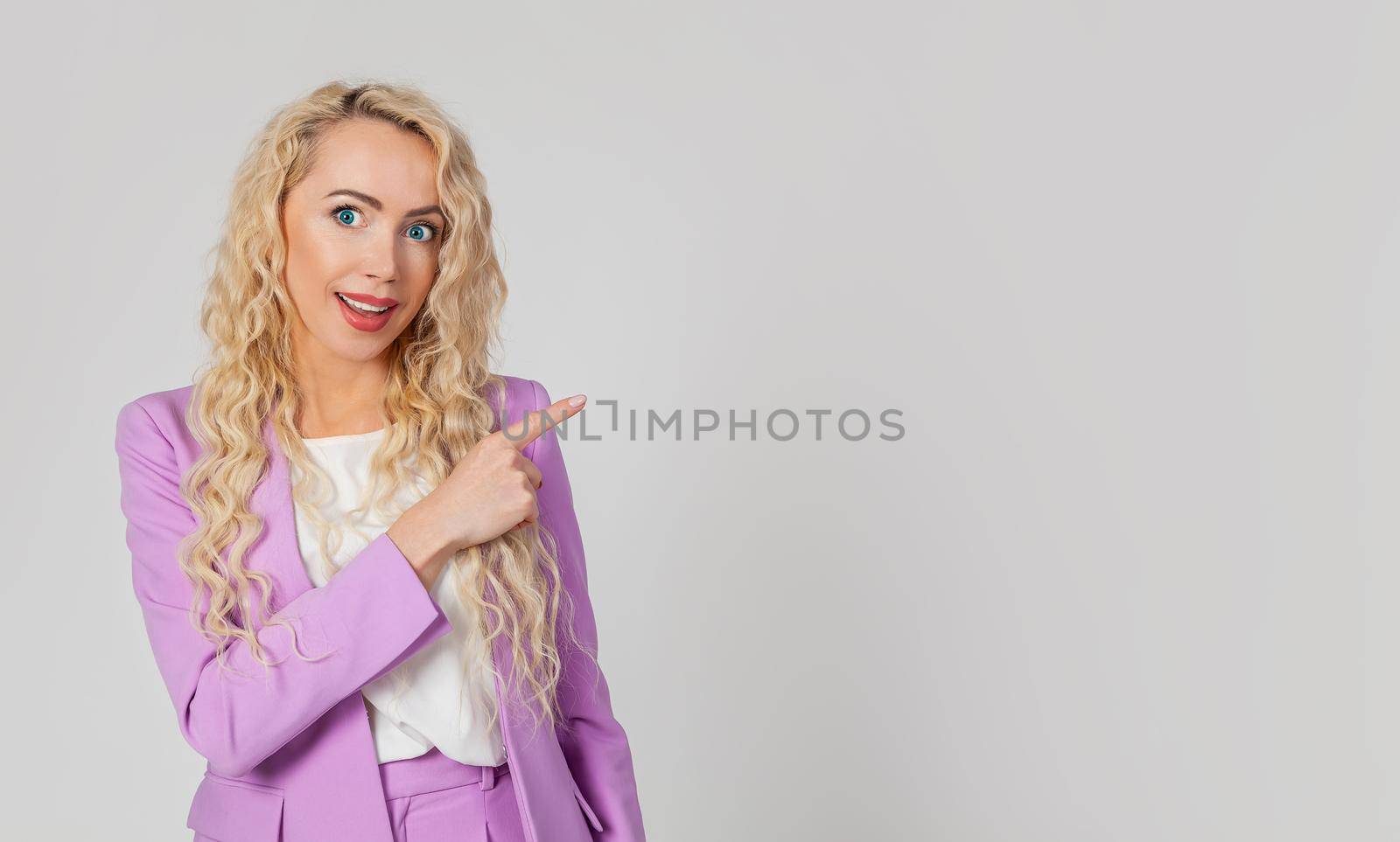 Intrigued, enchanted, blond woman, surprised lady, surprised, open mouth, indicates the direction to the right, happy, raises her eyebrows. Wow fiction say more