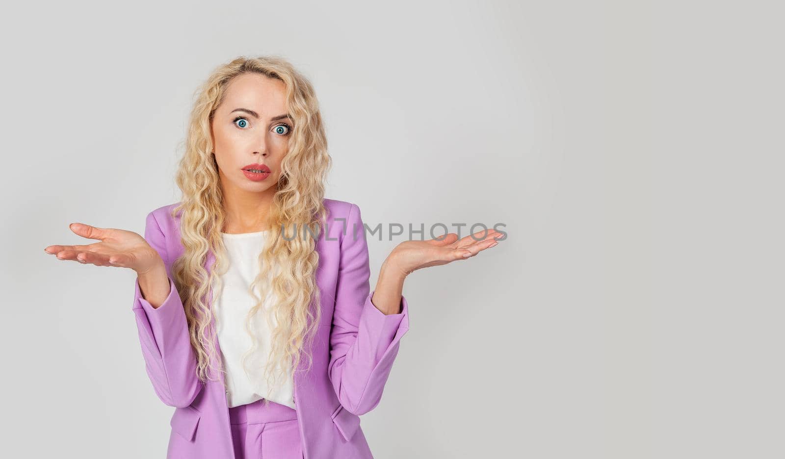 What's wrong. The embarrassed and intense woman shrugged, spread her arms. Shocked bewildered woman blonde colleague shrugging shoulders complete disbelief asks a question doubts puzzled situation