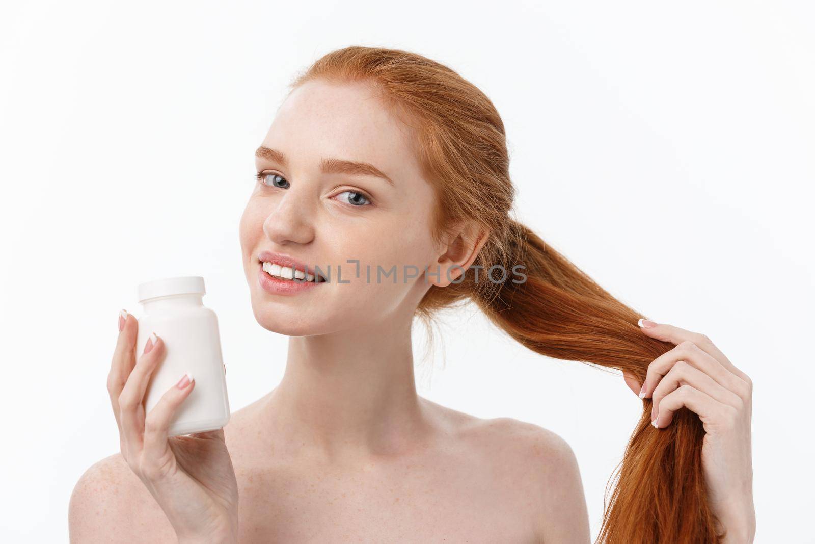 Portrait of good-looking young caucasian woman holding pills, trying to take care of immune system and health over gray background