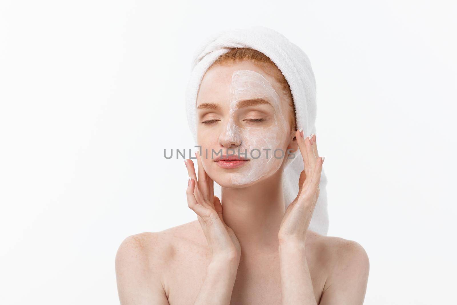 beautiful model applying cosmetic cream treatment on her face on white