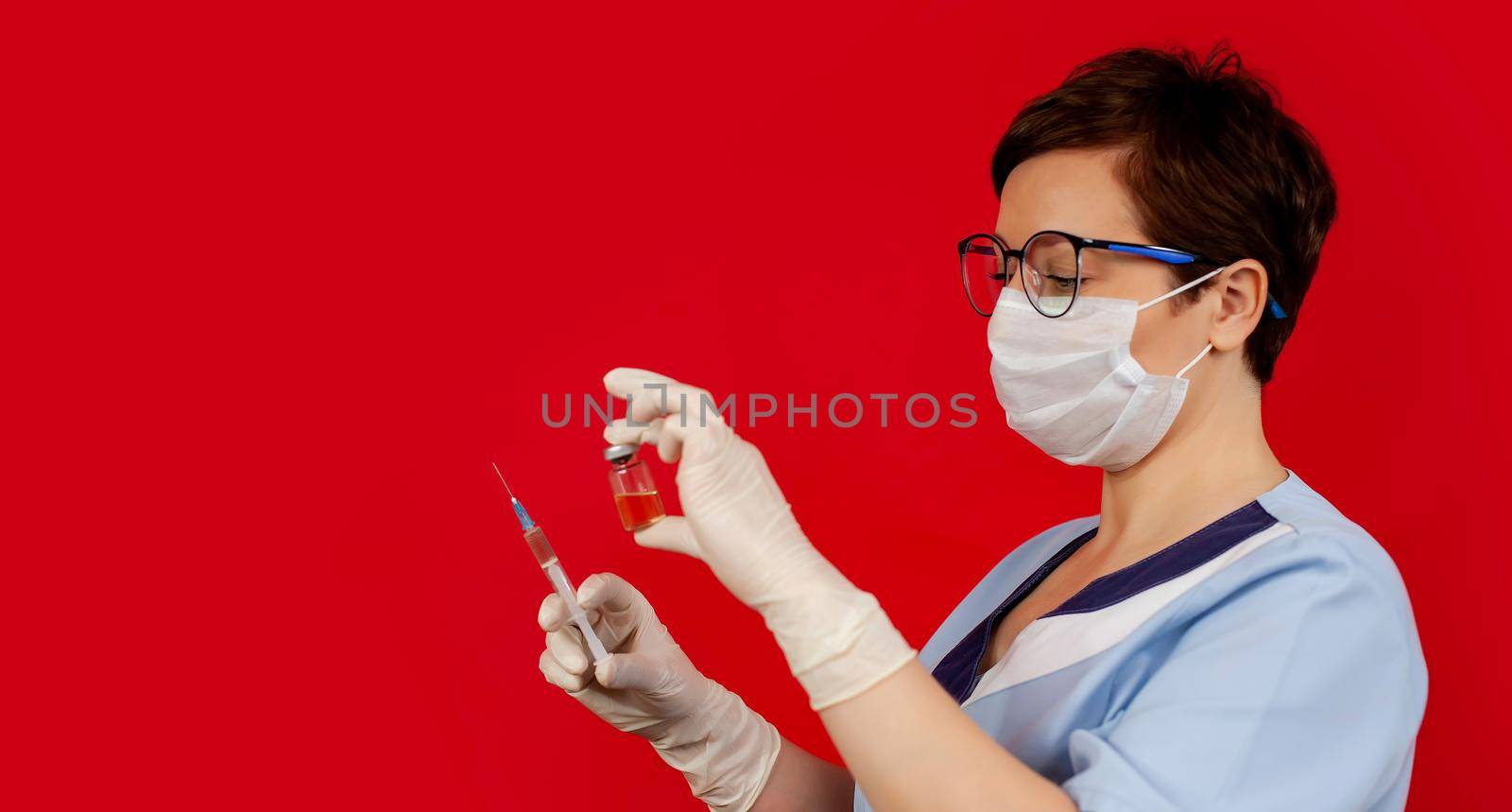 A doctor or nurse in nitrile gloves holds in his hand a vaccine vaccinated against influenza, measles, coronavirus COVID-19 for vaccination of children and adults, the concept of medicine and drugs.