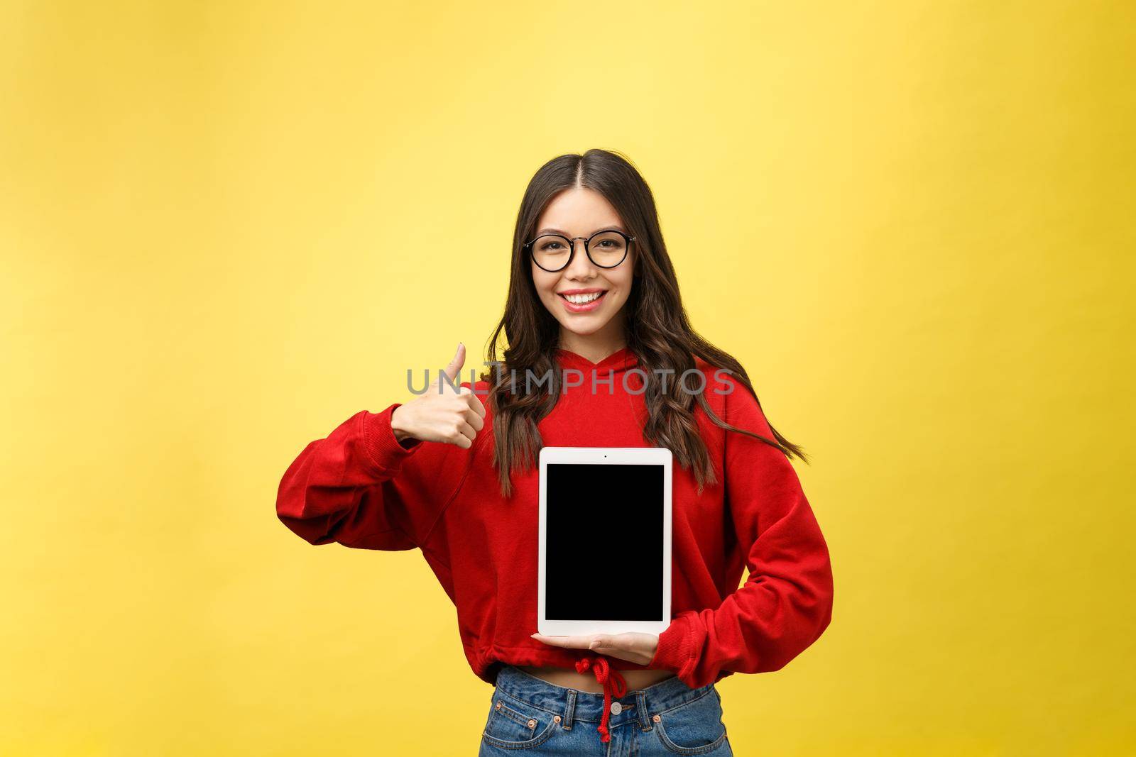 Woman using digital tablet computer PC isolated on yellow background by Benzoix