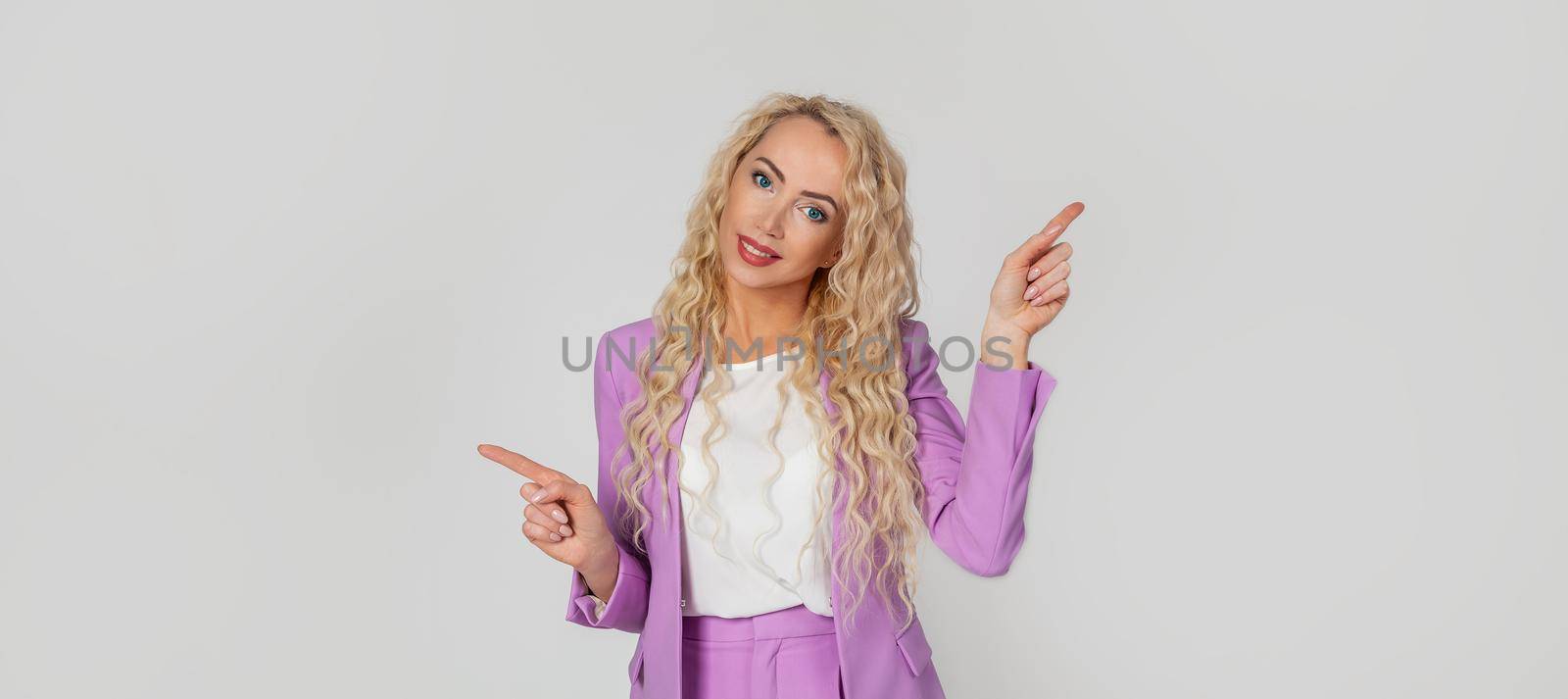 Pretty blonde woman smiles, gives advice, pointing sideways left and right, showing a good choice, promotes two products, both ways, standing on a white background